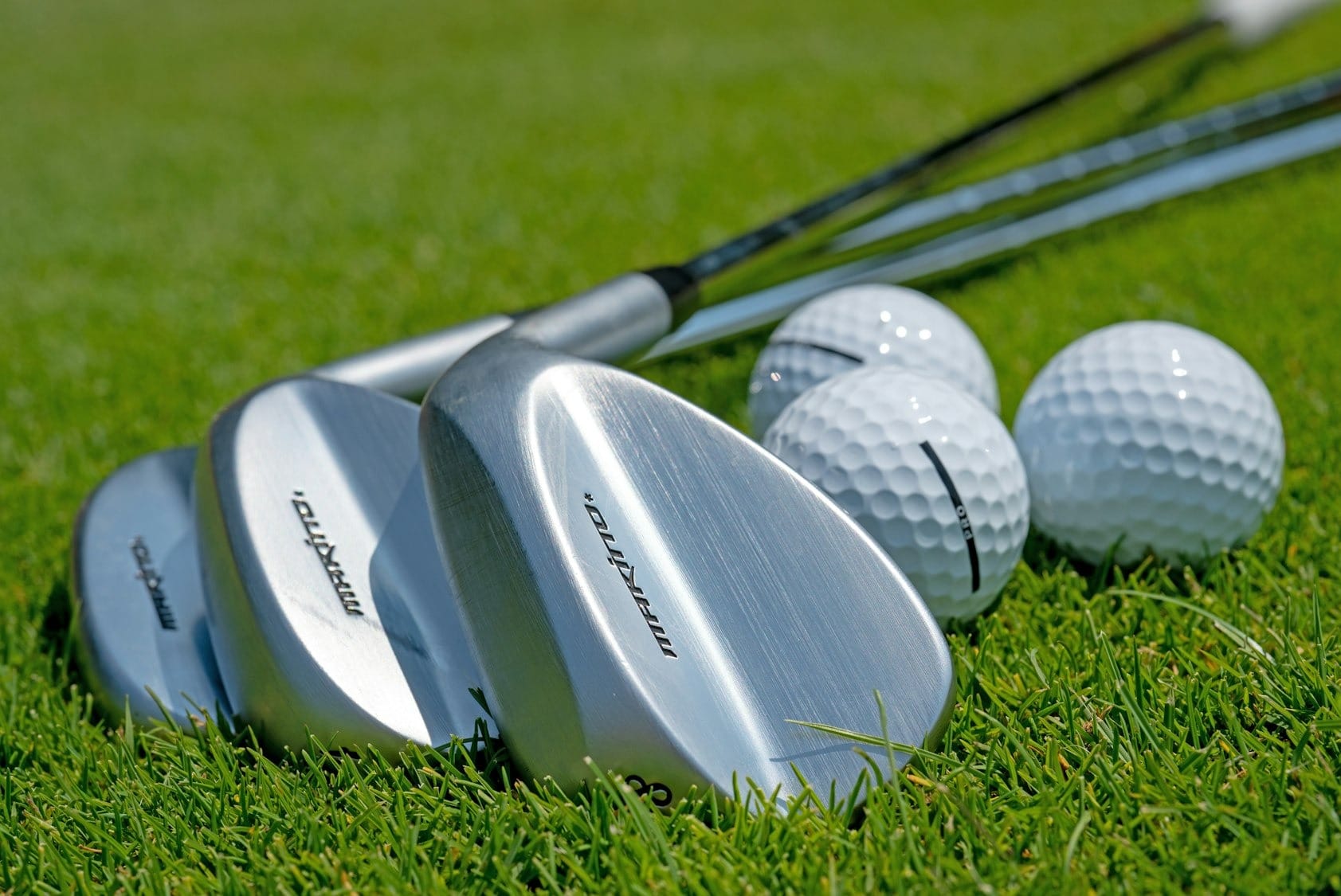 a group of golf clubs sitting on top of a lush green field