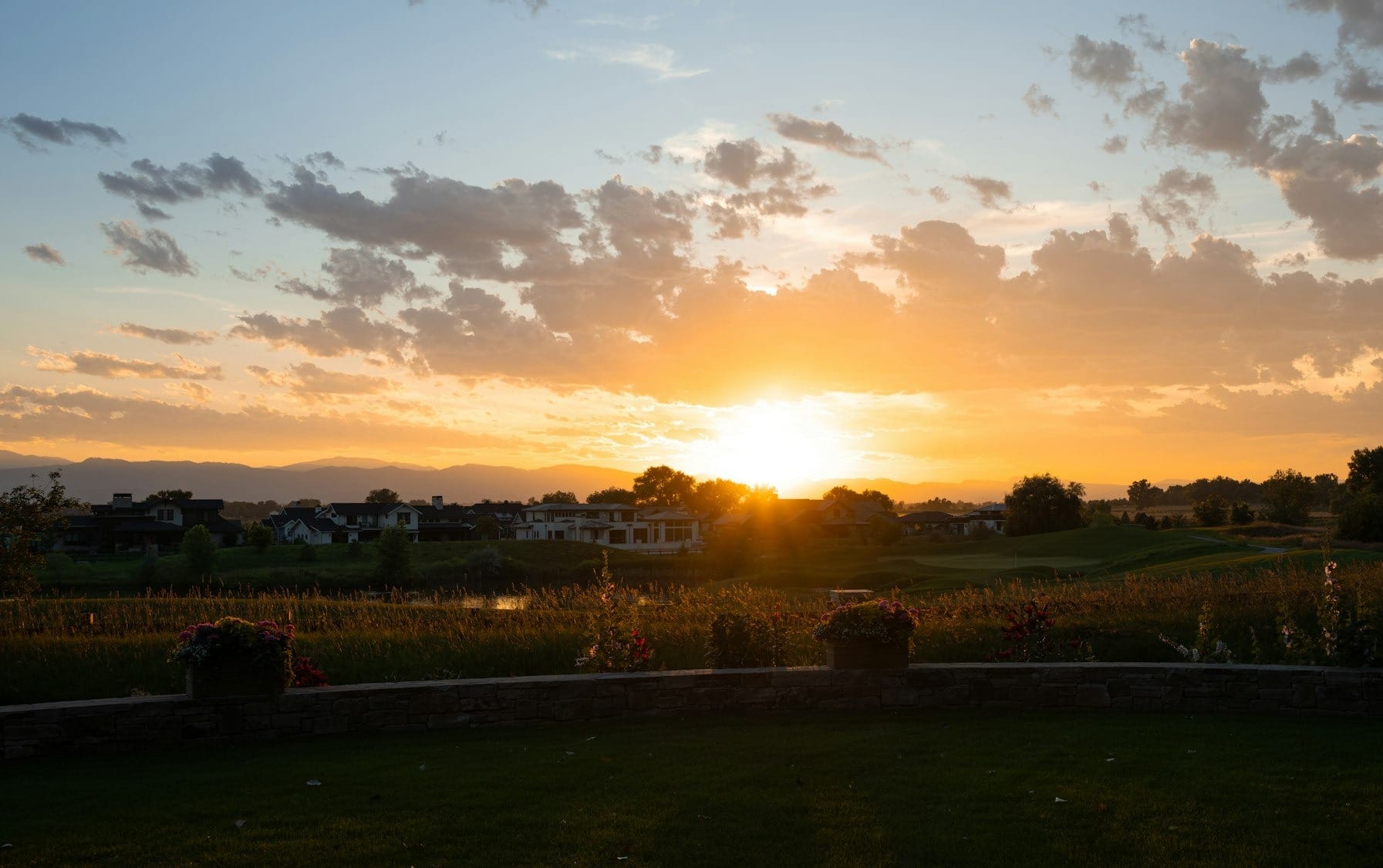 the sun is setting over a golf course